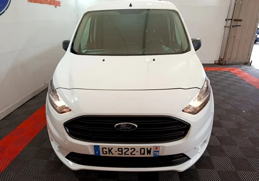 Vue avant d'un Ford Transit Fourgon blanc 2022 avec calandre noire et phares allumés en intérieur.