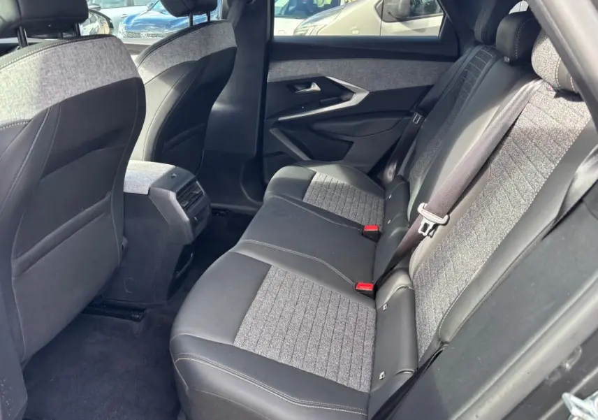 Vue intérieure arrière côté droit du Peugeot 3008 Hybrid 145 gris, sièges bi-matière tissu et cuir avec ceinture de sécurité.