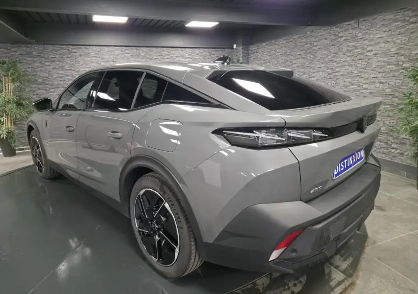 Vue 3/4 arrière droite d'une Peugeot 408 gris métallisé avec jantes alliage noires et feux arrière à LED distinctifs.