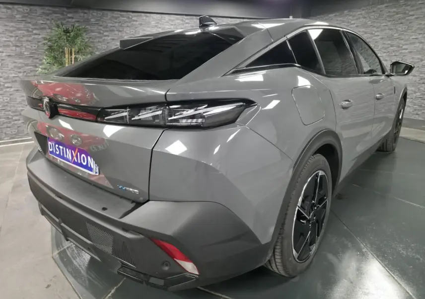 Vue 3/4 arrière droit d'une Peugeot 408 gris métallisé avec feux arrière LED griffés et jantes alliage 19 pouces.