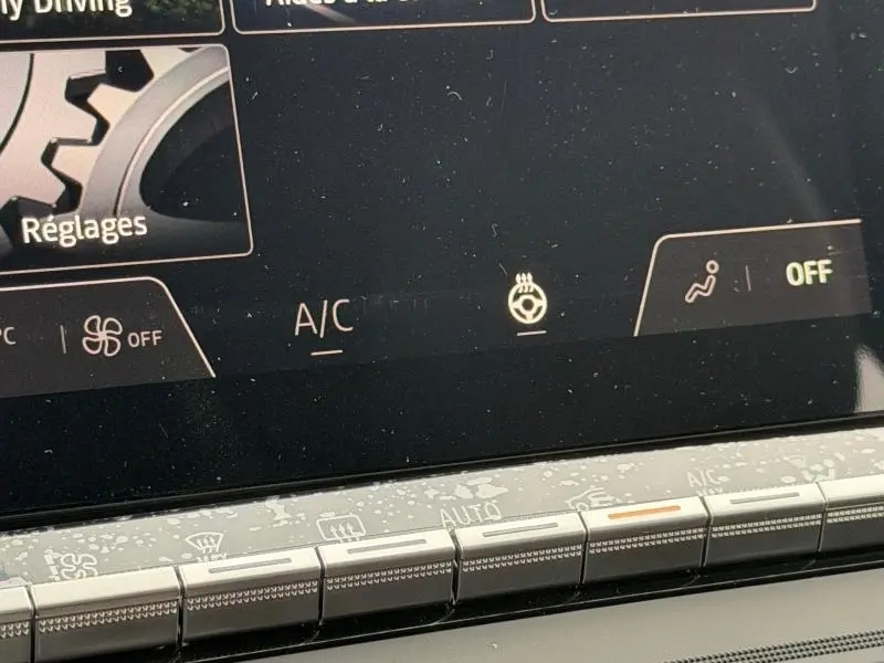 Écran tactile du tableau de bord du Renault Captur 2026 montrant les réglages climatisation et chauffage du volant.