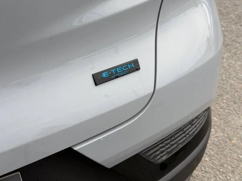 Gros plan sur l'arrière droit gris Rafale du Renault Captur 2026 avec le badge bleu E-Tech Hybrid visible.