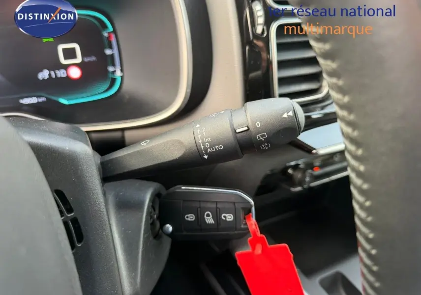 Gros plan sur la commande d'essuie-glace et la clé insérée dans le contacteur d'un Citroën C5 Aircross blanc nacré de 2019.