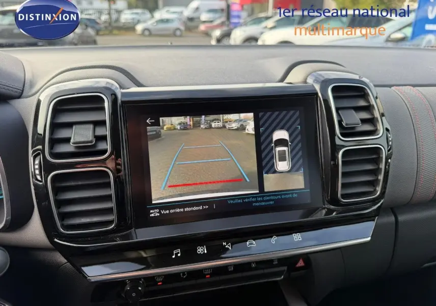 Vue rapprochée de l'écran multimédia affichant la caméra de recul dans l'habitacle noir du Citroën C5 Aircross blanc nacré.