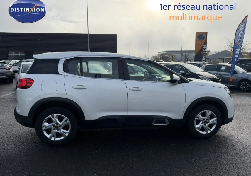 Vue de profil côté gauche d'un Citroën C5 Aircross blanc nacré avec jantes alliage et toit noir contrasté.