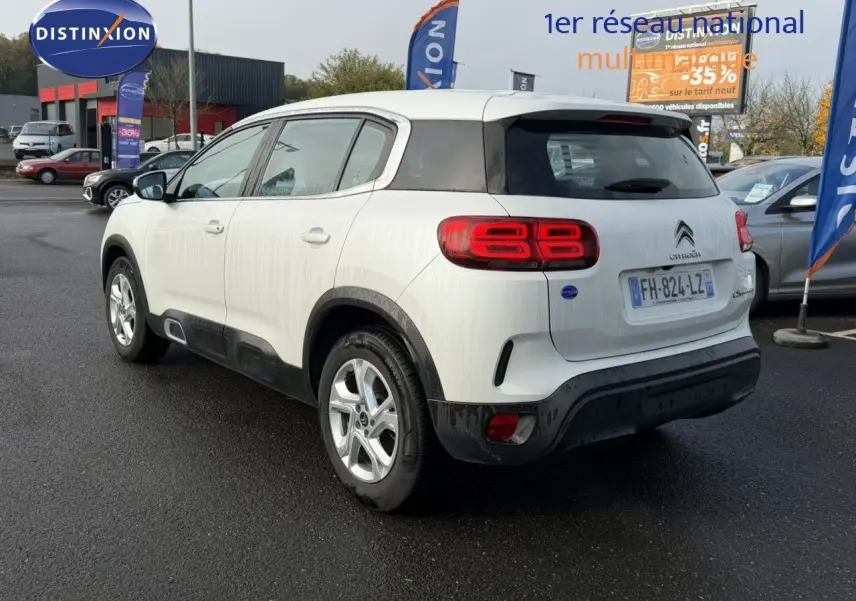 Vue 3/4 arrière droite du Citroën C5 Aircross blanc nacré avec feux arrière distinctifs et jantes alliage.