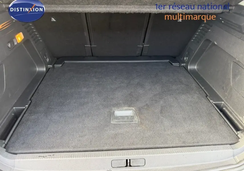 Coffre spacieux vu de face, intérieur noir avec tapis de sol et rangements latéraux du Citroën C5 Aircross blanc nacré.