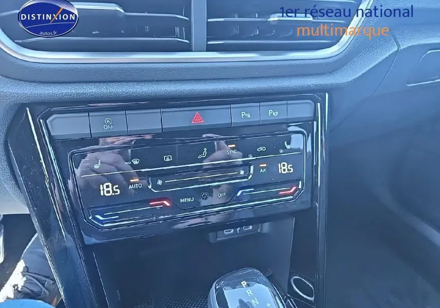 Vue rapprochée de la console centrale noire du Volkswagen T-Roc 2025 avec commandes clim et levier de boîte auto DSG7.