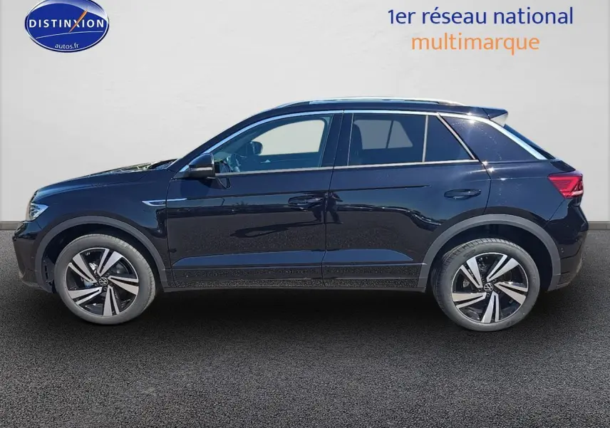 Profil côté gauche d'un Volkswagen T-Roc noir perle 2025 avec jantes alliage et barres de toit argentées.