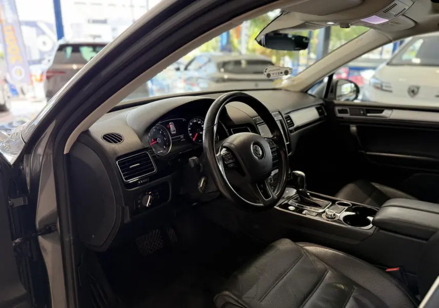 Intérieur noir cuir du Volkswagen Touareg 2017, vue côté conducteur avec tableau de bord et volant visibles.