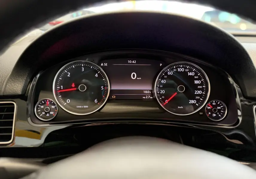 Vue rapprochée du tableau de bord du Volkswagen Touareg 2017, affichage numérique et compteurs analogiques noirs.