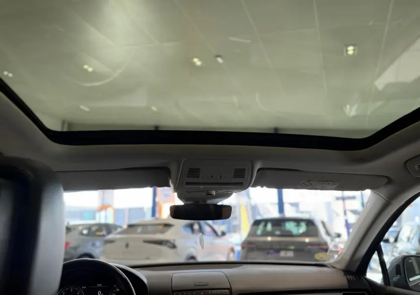 Vue intérieure avant du Volkswagen Touareg gris foncé 2017 avec toit ouvrant panoramique et tableau de bord épuré.