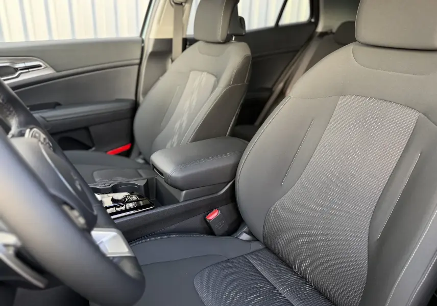 Coffre ouvert d'un KIA SPORTAGE gris Sirius 2025, vue arrière montrant l'espace de chargement vide.