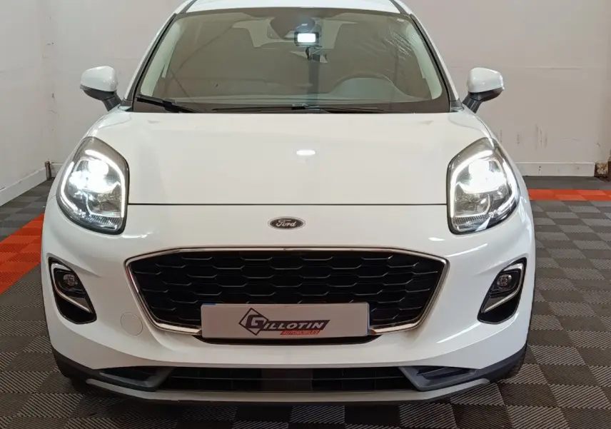 Vue frontale d'un Ford Puma blanc 2022 avec phares allumés et calandre noire distinctive.