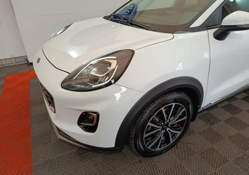 Vue 3/4 avant droit d'une Ford Puma blanche avec phares LED et jantes alliage noires brillantes.