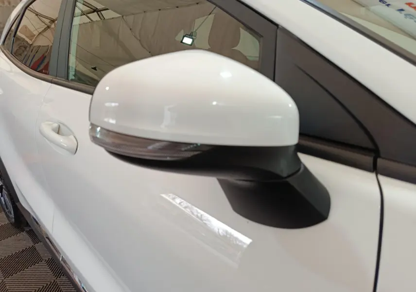 Gros plan sur le rétroviseur droit blanc du Ford Puma 2022, avec la portière et la poignée visibles en arrière-plan.