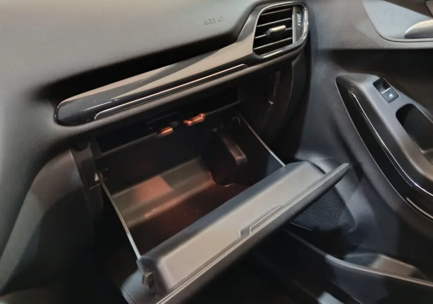 Vue intérieure côté passager du Ford Puma 2022 blanc, boîte à gants ouverte et tableau de bord noir.