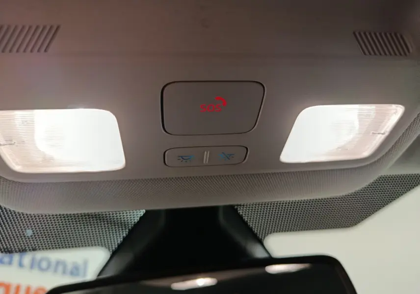 Vue intérieure du plafonnier avec bouton SOS rouge et éclairages de lecture allumés dans une Ford Puma blanche.