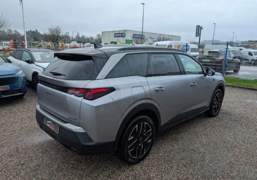Vue 3/4 arrière droite du Peugeot 5008 gris métallisé 2025 avec feux arrière à LED 3 griffes et jantes alliage 19 pouces.