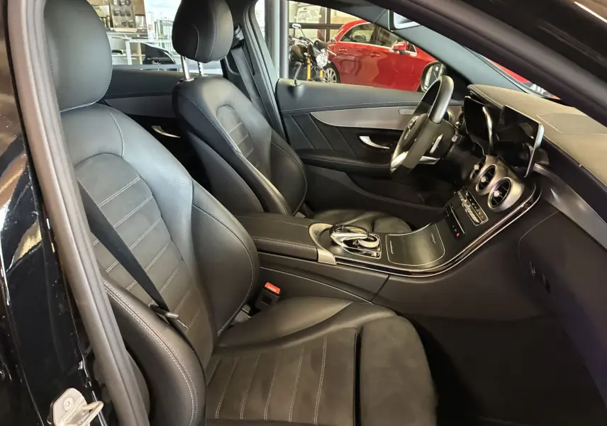 Intérieur noir cuir et alcantara d'une Mercedes Classe C Break 220D AMG Line, vue côté conducteur avec tableau de bord moderne.