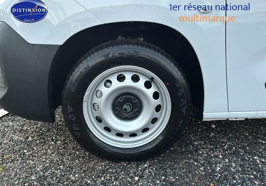 Gros plan sur la roue arrière droite d’un Citroën Berlingo Fourgon blanc avec jante acier et logo Citroën visible.