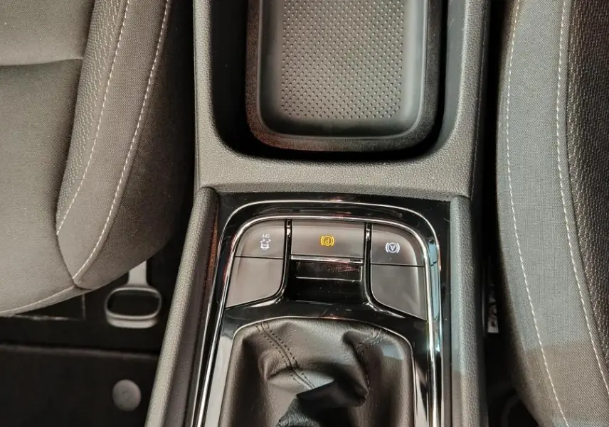 Vue plongeante sur la console centrale noire du Skoda Karoq 2024, mettant en valeur le levier de vitesse manuel et le frein à main électrique.