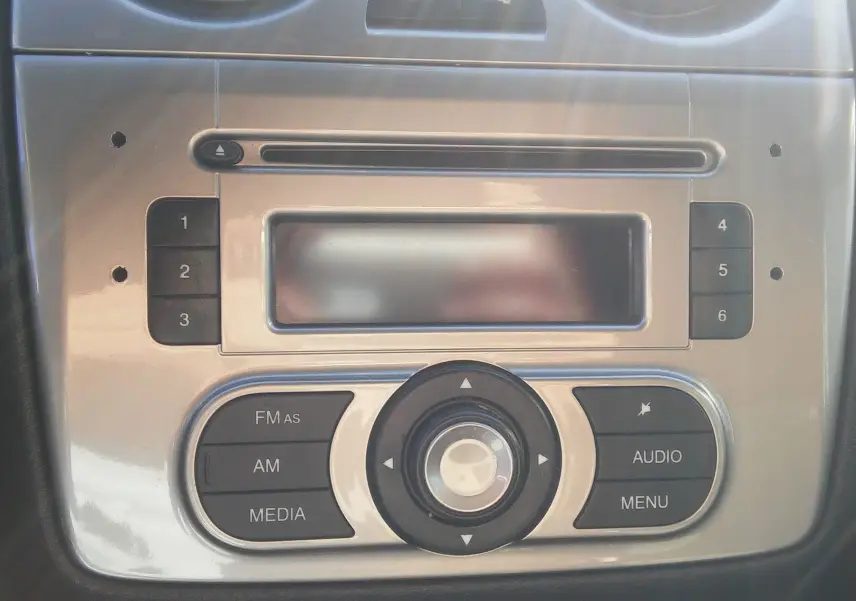 Gros plan sur la console centrale argentée de l'Alfa Romeo MiTo 2010, mettant en valeur les commandes audio et radio.