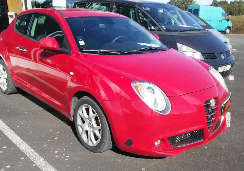 Alfa Romeo MiTo rouge vue 3/4 avant droit, avec jantes alliage et calandre caractéristique en V.