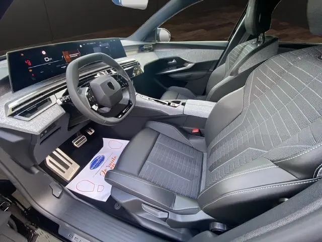 Intérieur avant droit du Peugeot 5008 2025 noir Perla avec tableau de bord numérique et sièges cuir tissu gris-noir