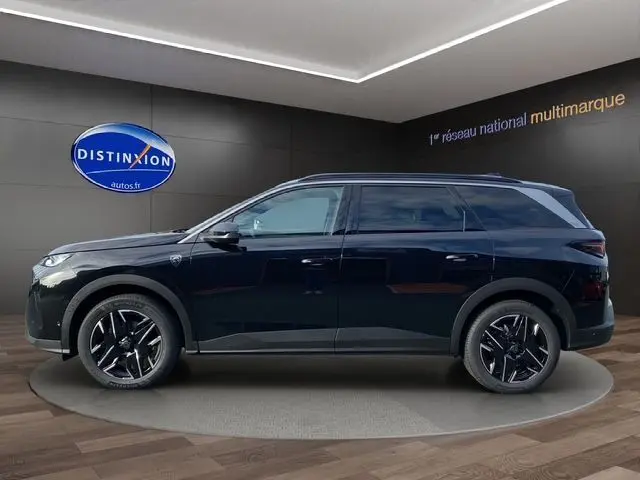 Profil latéral droit du Peugeot 5008 noir Perla Nera avec jantes alu 19'' et vitres arrière surteintées en showroom