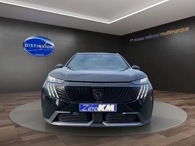 Vue frontale d'un Peugeot 5008 noir Perla Nera avec phares LED et calandre distinctive en showroom.