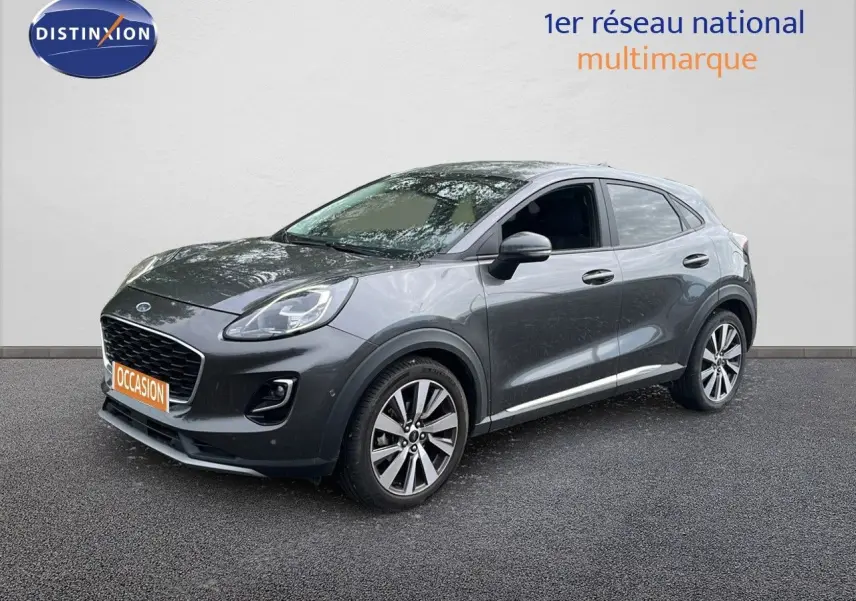 Ford Puma gris en 3/4 avant droit, mettant en valeur ses jantes alliage et son design compact moderne.