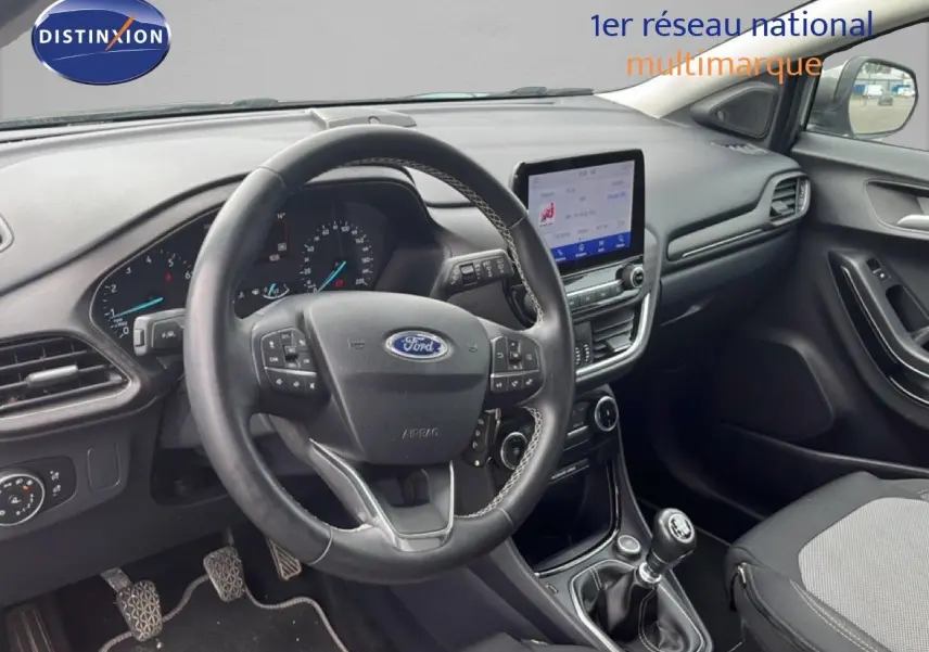 Vue intérieure du poste de conduite du Ford Puma gris 2021, avec volant multifonction et écran tactile central.