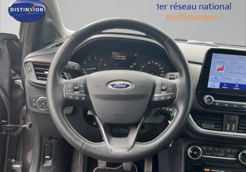 Vue intérieure centrée sur le volant Ford Puma gris 2021 avec tableau de bord numérique et écran tactile central.