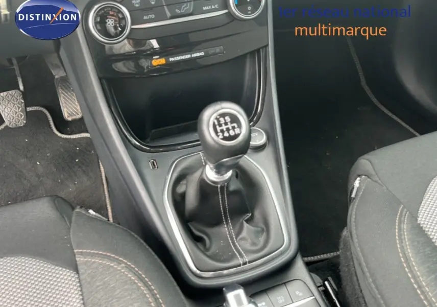 Gros plan sur la console centrale du Ford Puma gris 2021, mettant en valeur le levier de vitesse manuel et les sièges tissu.