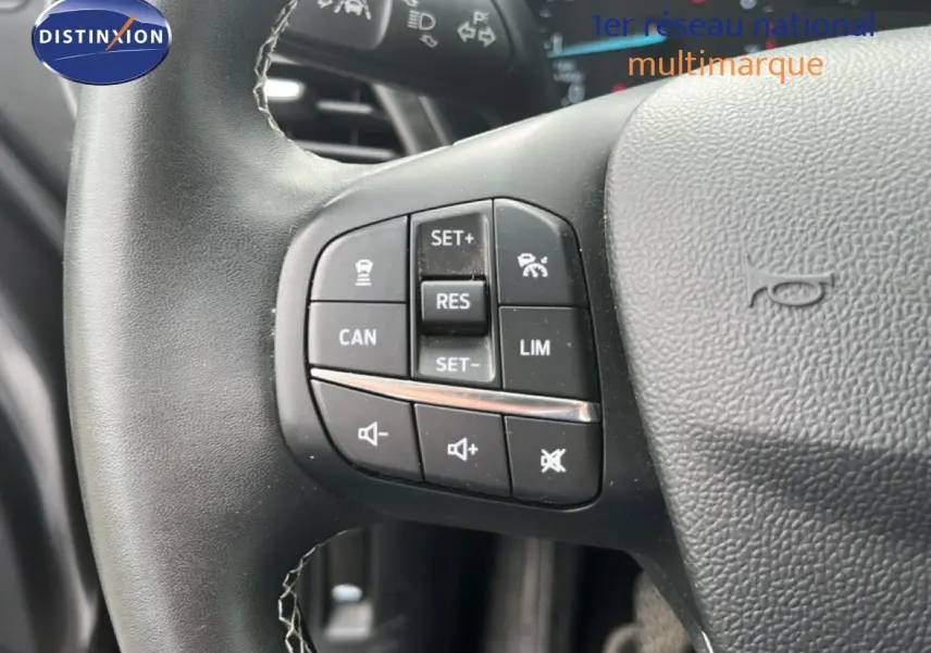 Gros plan sur les commandes du volant noir du Ford Puma gris, version 1.0 EcoBoost 125 mHev Titanium de 2021.