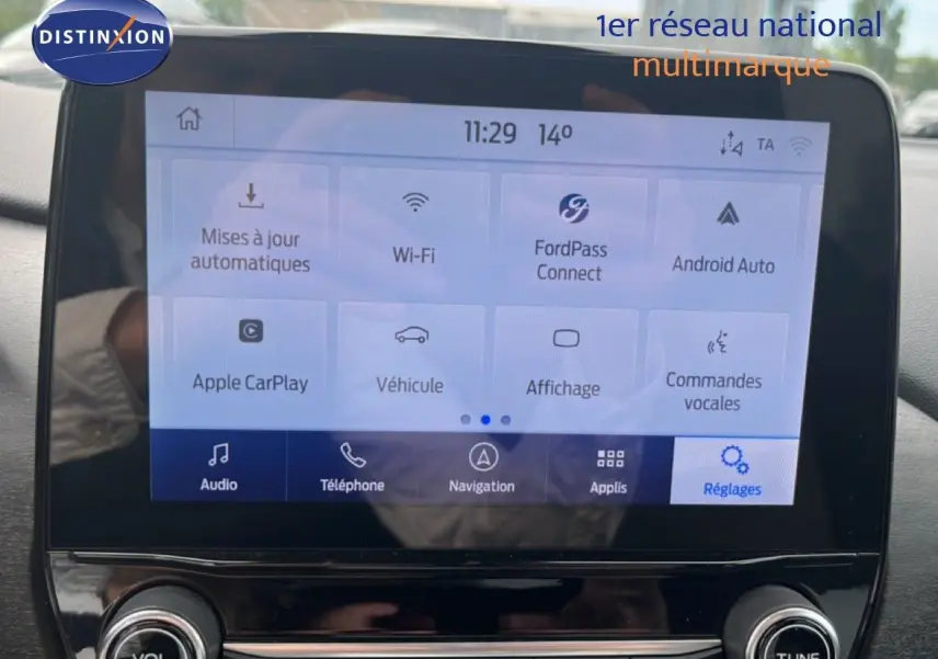 Écran tactile central du Ford Puma gris 2021 affichant les options connectivité et réglages, vue de face en intérieur.