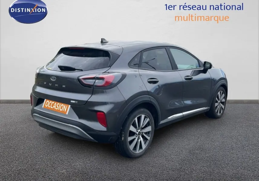 Ford Puma gris 3/4 arrière droit, SUV compact hybride essence avec jantes alliage et feux arrière LED.