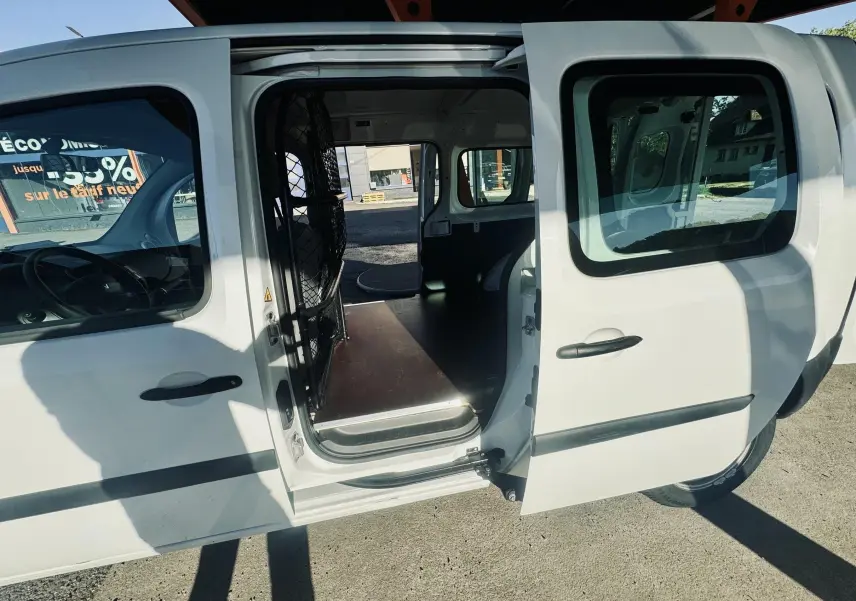 Vue latérale gauche d’un Renault Kangoo blanc avec porte coulissante ouverte montrant l’espace de chargement vide.