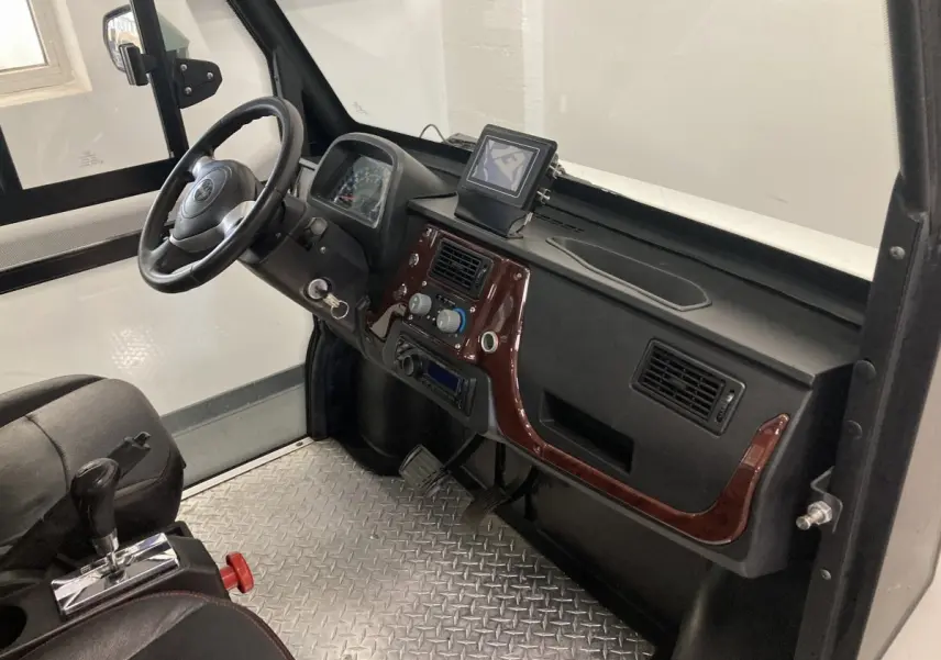 Vue intérieure côté conducteur du Liberty L7E H2 160 blanc, avec volant 3 branches, tableau de bord noir et sol en aluminium antidérapant.