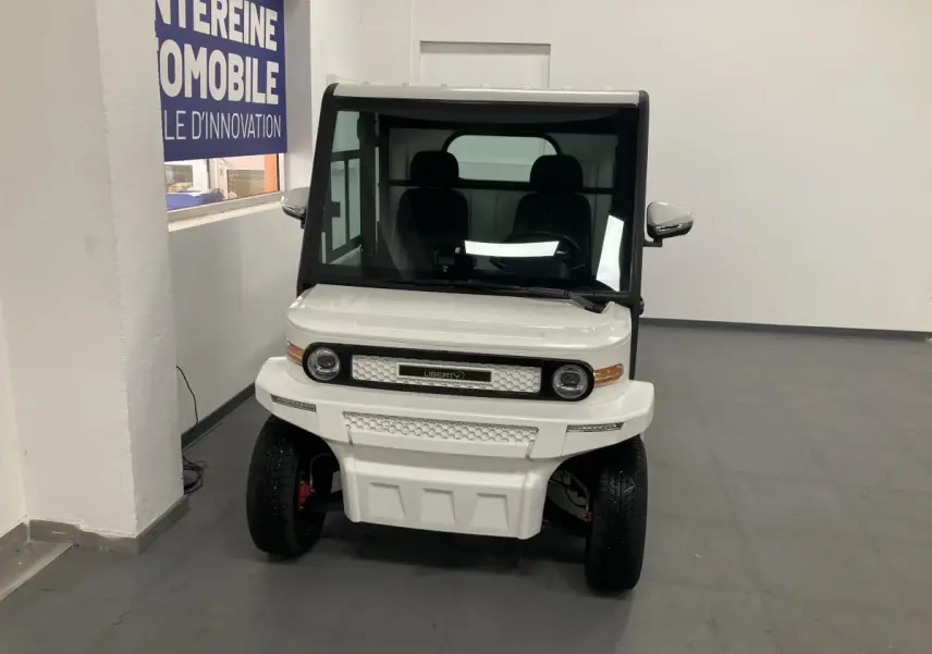 Vue de face du véhicule électrique blanc Liberty L7E H2 160 KIT RIDELLES avec phares ronds et calandre hexagonale.