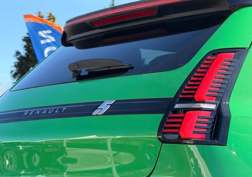 Vue arrière droite d'une Renault R5 E-TECH électrique en vert Pop avec feux arrière rouges et bande noire siglée Renault.