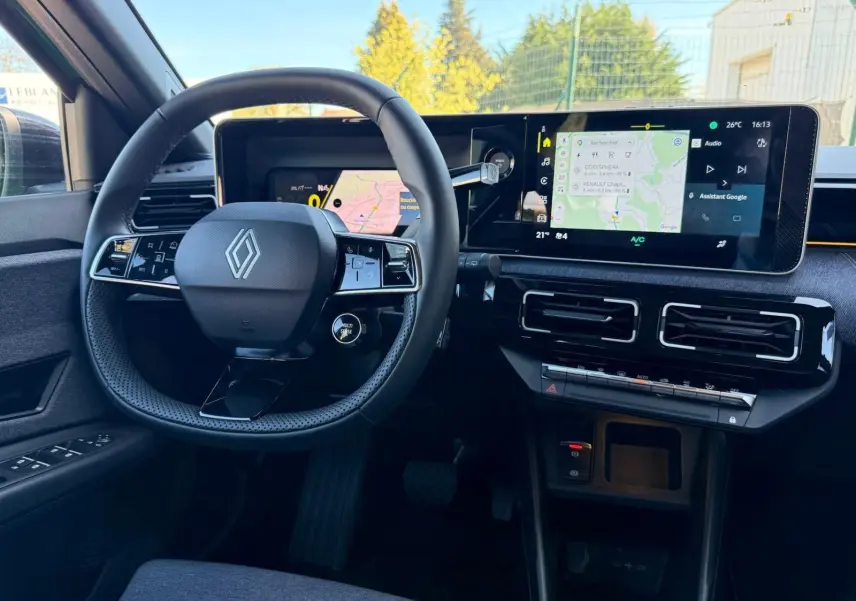 Vue intérieure du poste de conduite de la Renault R5 E-TECH 100% électrique, avec volant compact et écran tactile large.
