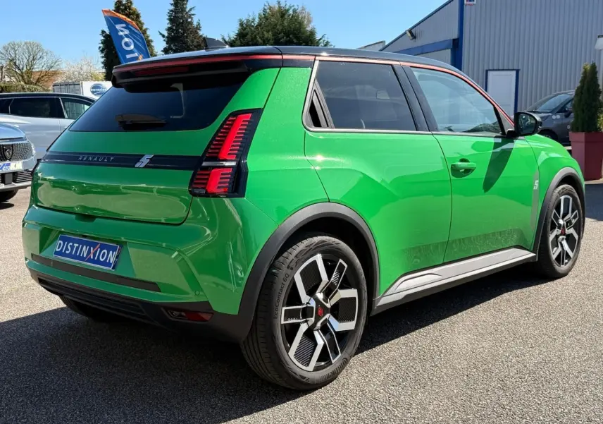 Vue 3/4 arrière droite d'une Renault R5 E-TECH électrique 2024 vert Pop avec toit noir étoile et jantes bi-ton.