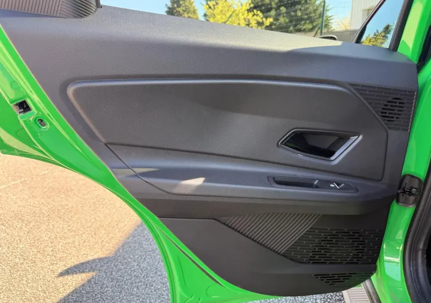 Vue intérieure de la porte arrière gauche verte du Renault R5 E-TECH 100% électrique 2024 avec poignée et commandes fenêtres.