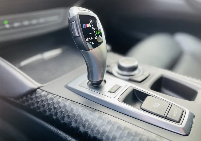 Le levier de vitesse M argenté en gros plan dans l'habitacle noir du BMW X6 50D Phase 2.