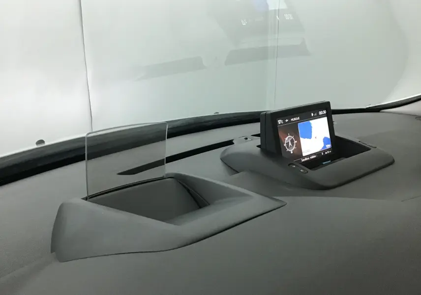 Détail du tableau de bord du Peugeot 3008 2015 avec écran GPS escamotable et afficheur tête haute transparent.