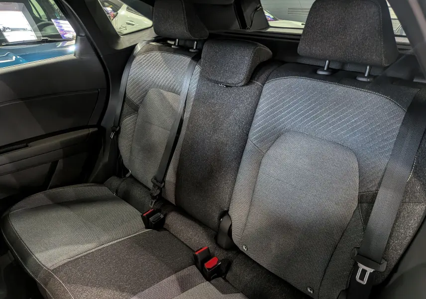 Vue intérieure arrière montrant les sièges arrière en tissu gris du Renault Symbioz E-Tech full hybrid 2025.