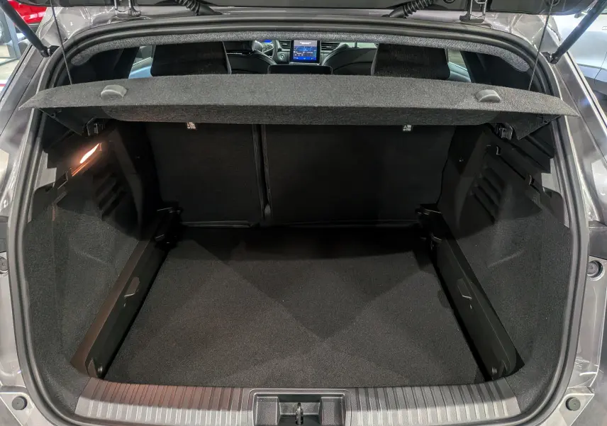 Coffre ouvert vu de l'arrière d'une Renault SYMBIOZ gris Cassiopé, montrant l'espace de chargement et la tablette cache-bagages.