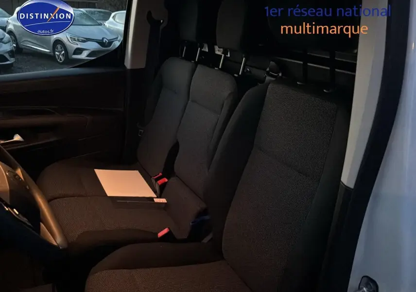 Vue intérieure côté conducteur du Citroën Berlingo Fourgon blanc 2025, montrant les sièges avant noirs et la cloison pleine.